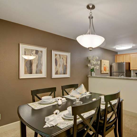 The dining room with a dining table and chairs and a view of the kitchen at Island Park. 