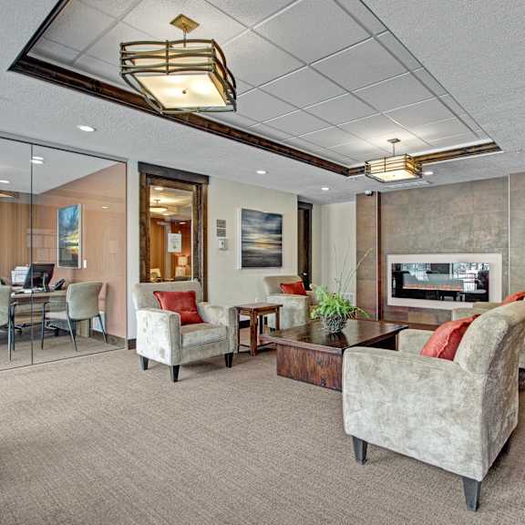 A living room with couches and chairs and a fireplace in Velo on the Boulevard.