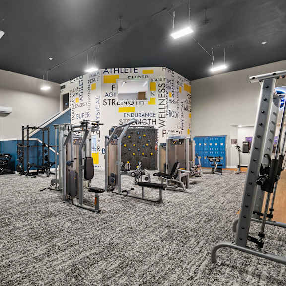 A gym with a variety of equipment including weights and machines.