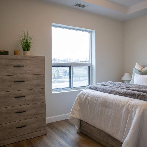 a bedroom with a bed, two nightstands, and a bench