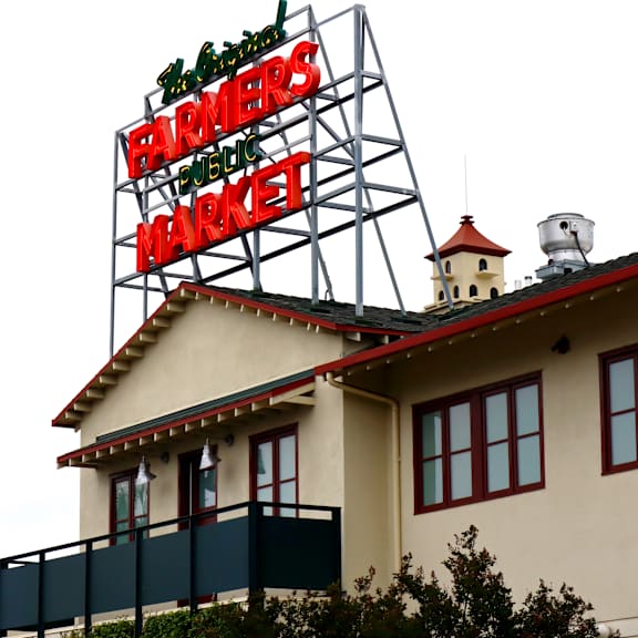 A large sign that says Farmers Market is displayed on a building.
