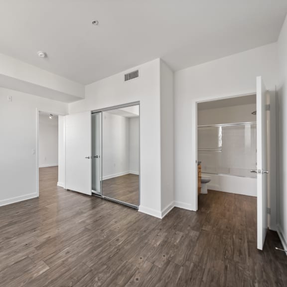 a bedroom with hardwood floors and white walls