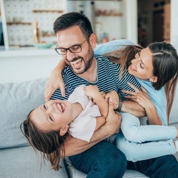 a man and two women sitting on a couch holding a baby