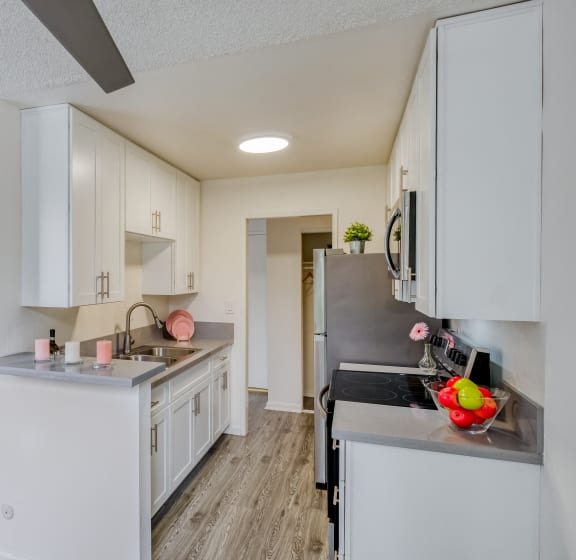 a renovated kitchen with white cabinets and a large counter top