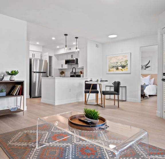 an open living room and kitchen with a table and chairs