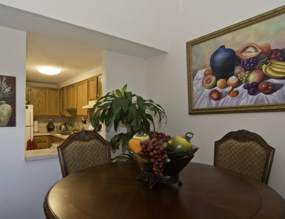 a dining room table with a bowl of fruit on it