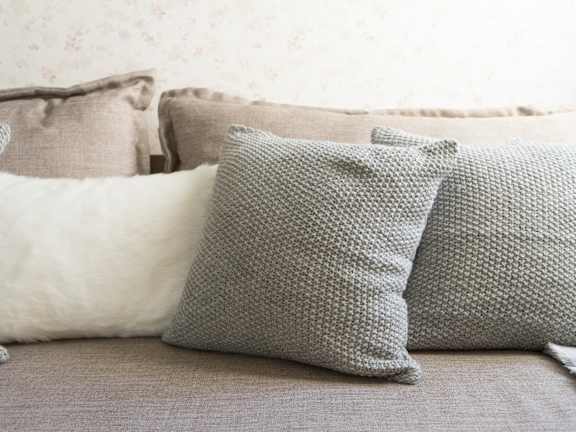 Three pillows on a couch with a textured pattern.