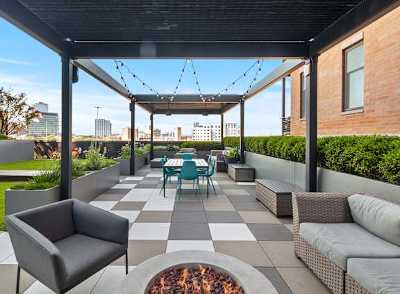 A patio with a fire pit and seating area.