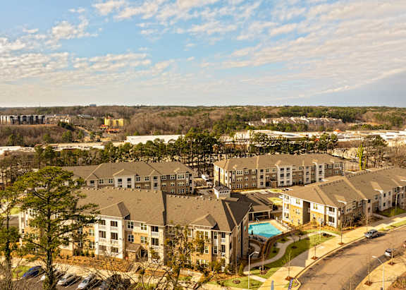 A large apartment complex with a swimming pool in the middle.