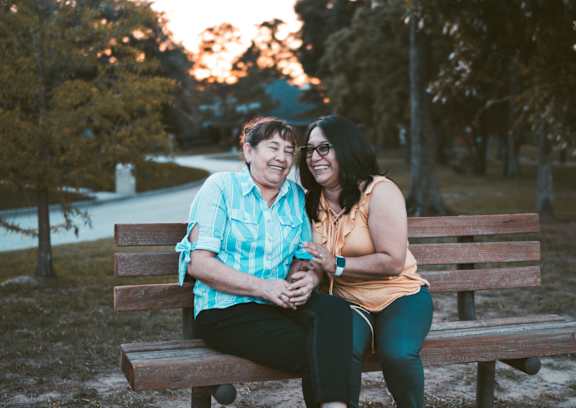 Two women sitting on a bench in a park at Union at Rivers Edge, Des Moines, IA