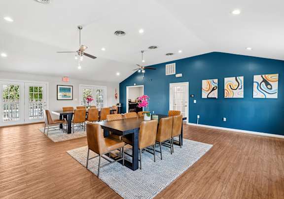 A dining room with a table set for six with chairs around it.