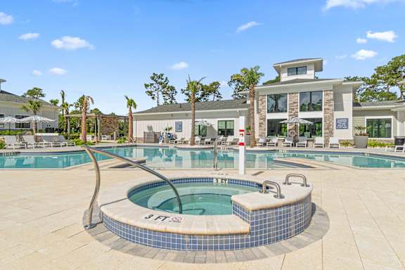 A hot tub sits in the middle of a pool surrounded by a tiled patio.