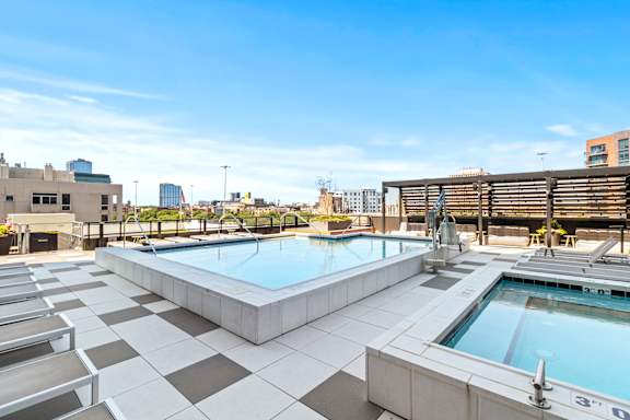 A large outdoor swimming pool with a black and white checkered floor.