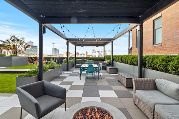 A patio with a fire pit and seating area.