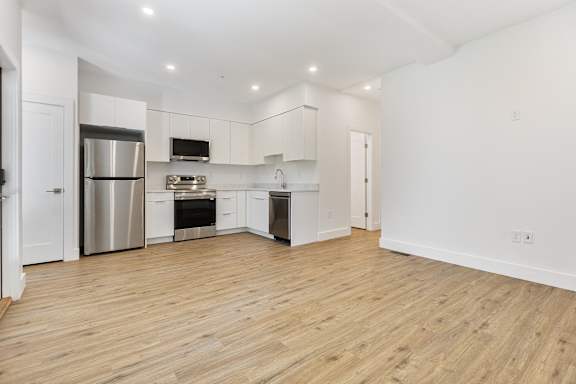 A kitchen with white cabinets and stainless steel appliances.