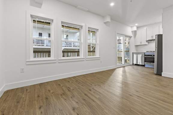 A kitchen area with a refrigerator, cabinets, and a countertop.