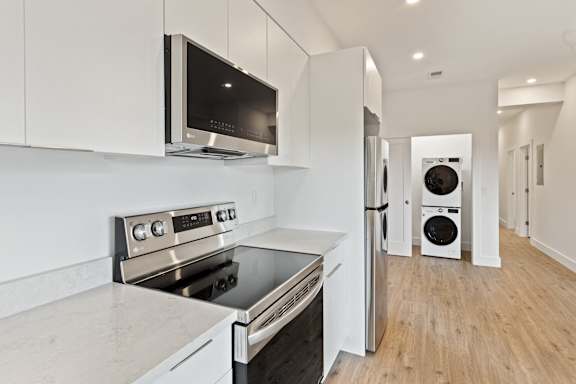 A modern kitchen with a stainless steel oven and microwave.