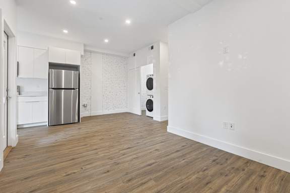 A spacious kitchen with white cabinets and a stainless steel refrigerator.