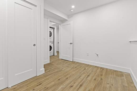 A hallway with a washer and dryer in the background.