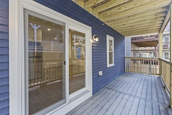 A balcony with a blue wall and wooden floor.