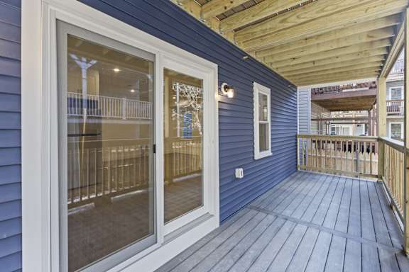 A balcony with a blue wall and wooden floor.