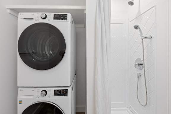 A white washing machine and dryer in a small laundry room.
