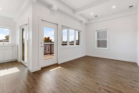 A large empty room with wooden floors and white walls.