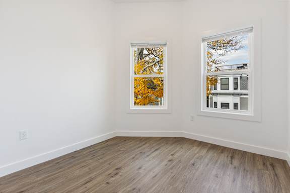 A room with a window showing a tree with yellow leaves.