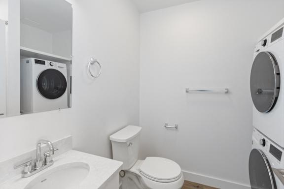 A white bathroom with a washing machine built into the wall.