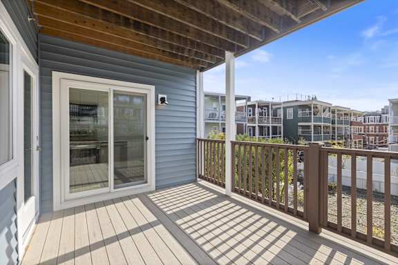 A deck with a sliding glass door and a railing.