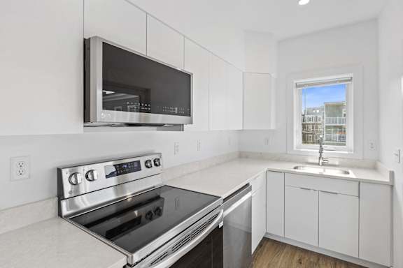 A modern kitchen with a stainless steel oven and microwave.