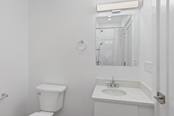 A white toilet and sink in a bathroom.