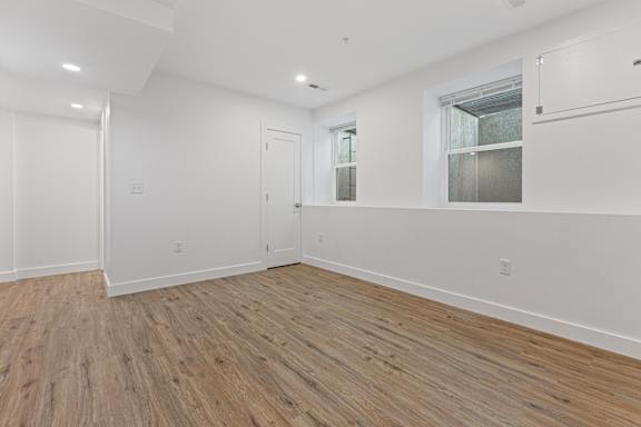 A room with wooden flooring and white walls.