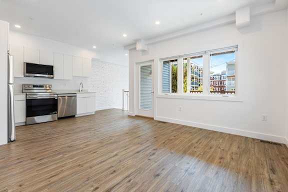 A kitchen with a refrigerator, oven, and microwave.