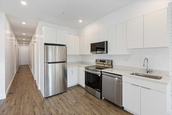 A modern kitchen with stainless steel appliances and white cabinets.