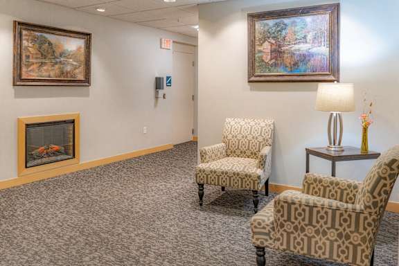 a waiting room with two chairs and a fireplace