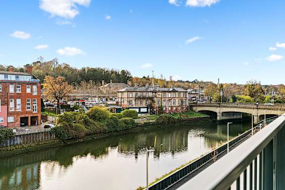 A river flows through a city with a bridge crossing over it.