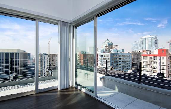 A room with a view of the city through large windows.
