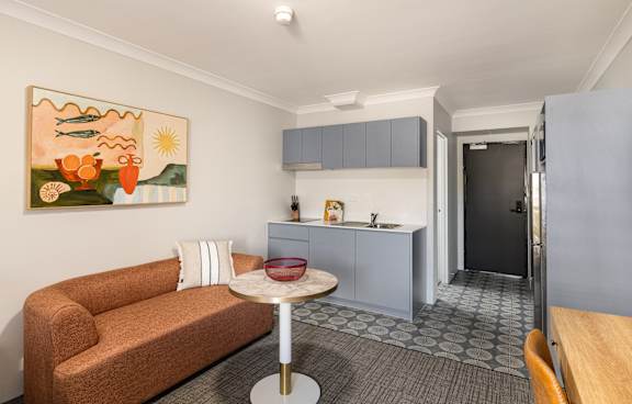 a living room with a green couch and a balcony