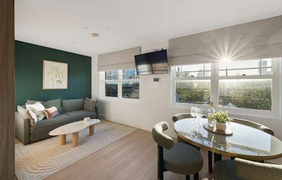 a living room with a green couch and a balcony