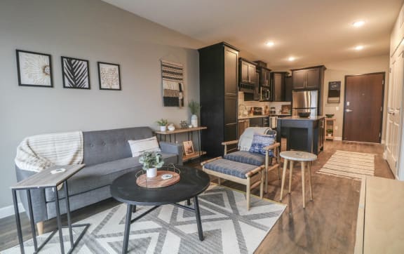 a living room with a couch and chairs and a kitchen  at Vue at Bluestone, Duluth, MN, 55803