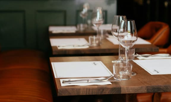 a wooden table with wine glasses and papers on it