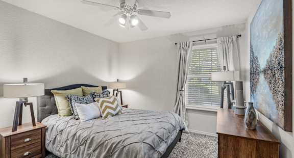 a bedroom with a bed and a ceiling fan