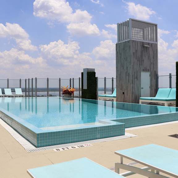 a swimming pool on the rooftop of a hotel with a skyscraper