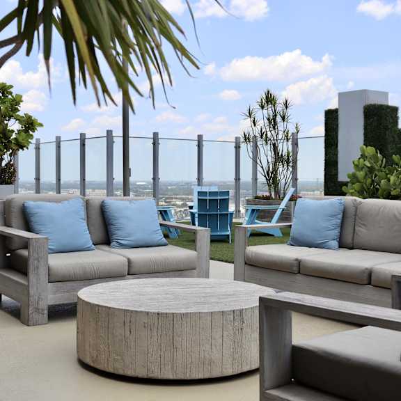 a patio with couches and tables on a roof top