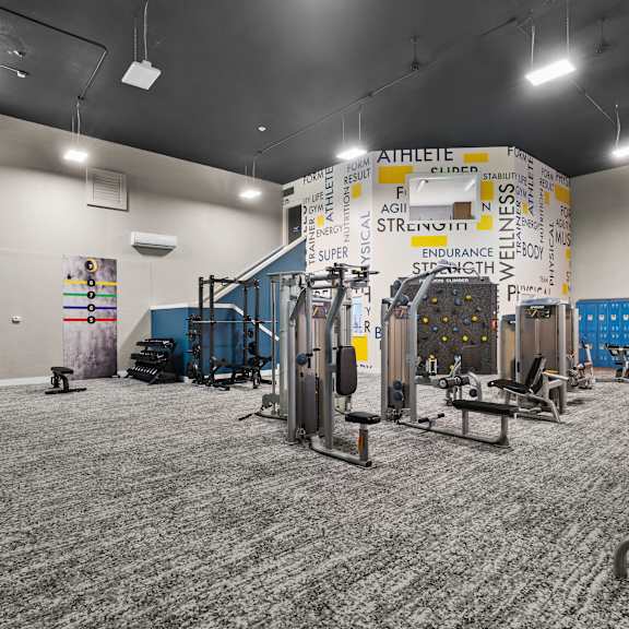 A gym with a variety of equipment including weights and machines.