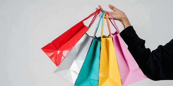 a hand holding a bunch of colorful shopping bags at Infinity on the Mark, Texas
