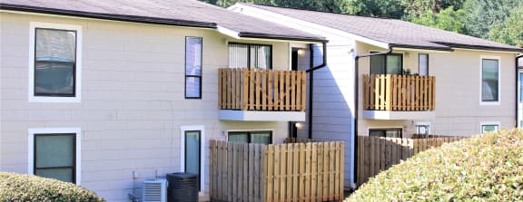 the back of a white house with a yard and a wooden fence