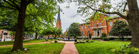 A brick pathway leads to a church with a steeple.