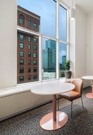 A room with a table and chairs and a picture on the wall.
